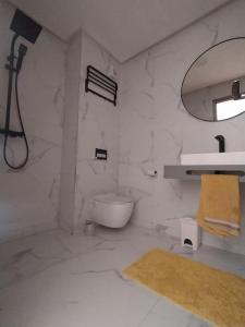La salle de bains blanche est pourvue d'un lavabo et de toilettes. dans l'établissement Belle Vue, à Marrakech