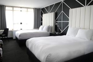 a hotel room with two beds and a window at Hotel NoMa, Trademark Collection by Wyndham in New Rochelle +20 photos