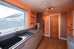 a kitchen with a sink and a window at Links Golf Villa in Troon