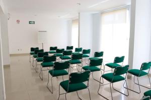 a room with green chairs and a podium at Hotel México Plaza Irapuato in Irapuato