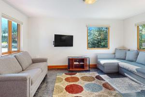 a living room with two couches and a tv at Girdwood Cozy Casita in Girdwood