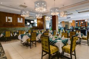 a dining room with tables and chairs and chandeliers at Protea Hotel by Marriott Benin City Select Emotan in Benin City