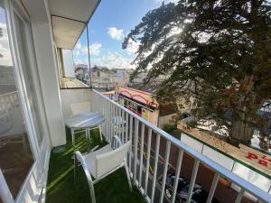 einen Balkon mit einem Tisch, Stühlen und einem Baum in der Unterkunft Appartement du bonheur ! Av de la Mer in Saint-Jean-de-Monts