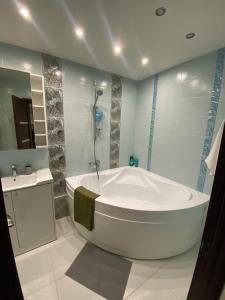 a bathroom with a large tub and a sink at Suite Apartment in Šiauliai