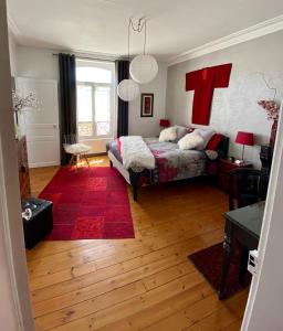 1 dormitorio con 1 cama y un osito de peluche rojo en la pared en Les Lamartine-chambres d'hôtes, en Le Mans