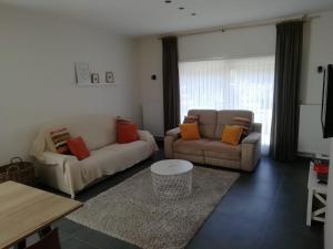 uma sala de estar com dois sofás e uma mesa em Huis Ter Duin em Koksijde