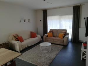 a living room with two couches and a table at Huis Ter Duin in Koksijde