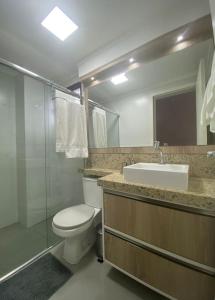 y baño con aseo, lavabo y ducha. en Loft Premium Torres RS, en Torres