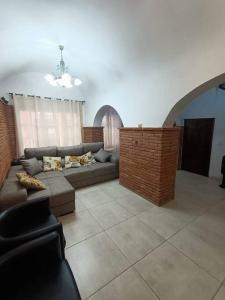 ein Wohnzimmer mit Sofa und Ziegelwand in der Unterkunft Apartamento Casa de pueblo in Sant Feliu de Guixols