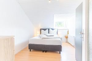 a white bedroom with a bed in a room at GOLDVILLA - Köln in Cologne