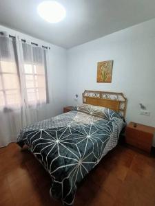 a bedroom with a bed with a comforter on it at Apartamento Casa de pueblo in Sant Feliu de Guíxols