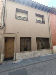 ein weißes Gebäude mit drei Fenstern und einer Tür in der Unterkunft Apartamento Casa de pueblo in Sant Feliu de Guixols