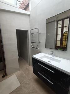 a white bathroom with a sink and a mirror at Apartamento Casa de pueblo in Sant Feliu de Guíxols