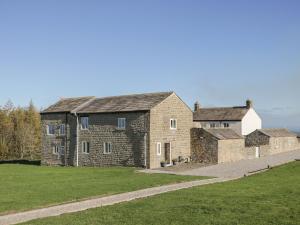 an old stone building with a grassy field next to it at The Hayloft in Ripon