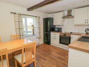 a kitchen with a wooden table and a dining room at The Hayloft in Ripon