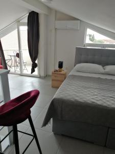 sypialnia z łóżkiem, krzesłem i oknem w obiekcie Milka w mieście Zadar