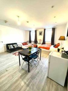 a living room with a table and a couch at Spacious Studio flat in Central London in London