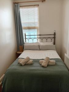 uma cama com duas almofadas com uma janela em Ocean City Apartment-with parking em Plymouth