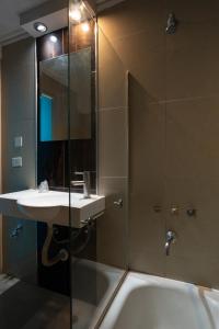 y baño con lavabo y ducha. en HOTEL AUSONIA en San Carlos de Bariloche