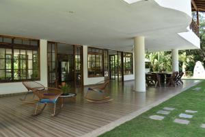 a building with chairs and tables on a wooden deck at Malía Casa Campo in Santa Marta