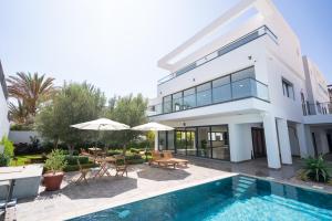 une villa avec une piscine et une maison dans l'établissement TigMAÏA Guest House In Agadir for Traditional Art and Culture, à Agadir