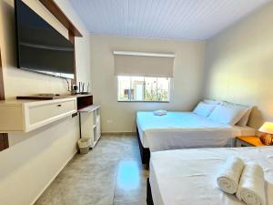 1 Schlafzimmer mit 2 Betten und einem Flachbild-TV in der Unterkunft Recanto Vó Alda c Piscina Sinuca prox Paraguai in Foz do Iguaçu