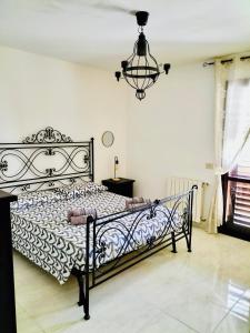 a bedroom with a black and white bed with a chandelier at Belvedere House Holiday Siracusa Ortigia in Belvedere