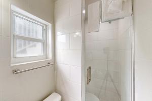 baño con ducha y aseo y ventana en Citrus Room en Marathon
