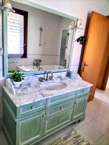 a bathroom with a sink and a large mirror at Belvedere House Holiday Siracusa Ortigia in Belvedere