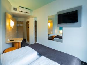 ヴッパータールにあるB&B HOTEL Wuppertal City-Südのベッド1台、薄型テレビが備わるホテルルームです。
