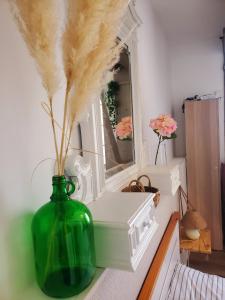 a green vase sitting on a table with a mirror at "Le Rive-Gauche" appartement tout équipé, 2 chambres à 2 pas de la gare -- WiFi - TV connectée in Châlons-en-Champagne