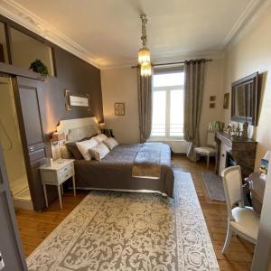 Un dormitorio con una cama y una ventana grande. en Les Lamartine-chambres d'hôtes, en Le Mans