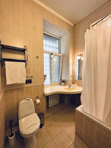 a bathroom with a toilet and a sink and a shower at Classic Hotel in Kharkiv
