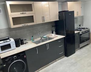 a kitchen with a sink and a refrigerator at Haya Guest House in Kʼanakʼerravan