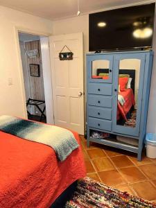 a bedroom with a bed and a dresser with a mirror at Pearls Pad - Beautiful 1 bedroom apartment- 1 block to beach in Tybee Island