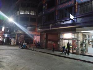 a group of people walking down a street at night at RIXAA Hotels in La Paz