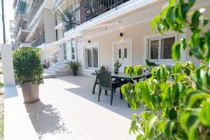 a patio with a table and chairs and plants at Joanna Luxury Apartment in Preveza