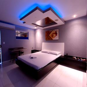 um quarto com uma cama com iluminação azul em GRAN MOTEL GYN em Goiânia