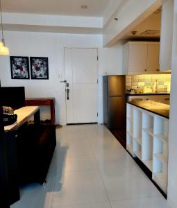 a kitchen with a white floor and a white door at Cozy and Spacious Condo Unit with Free Netflix in Manila