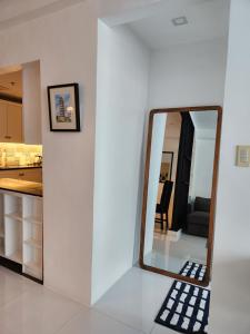 a mirror on a white wall in a kitchen at Cozy and Spacious Condo Unit with Free Netflix in Manila