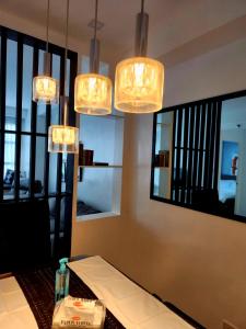 a dining room with a table and several lights at Cozy and Spacious Condo Unit with Free Netflix in Manila