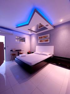 1 dormitorio con 1 cama con iluminación azul en GRAN MOTEL GYN en Goiânia