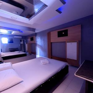 1 dormitorio con 2 camas y TV. en GRAN MOTEL GYN en Goiânia