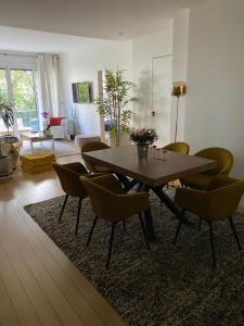 a living room with a wooden table and chairs at Appartement 65m2 avec balcon in Neuilly-sur-Seine