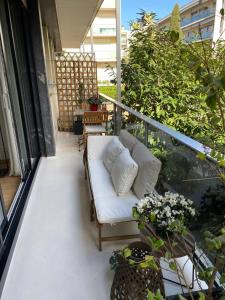 a balcony with a white couch and some plants at Appartement 65m2 avec balcon in Neuilly-sur-Seine