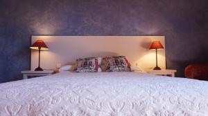 a bedroom with a large bed with two lamps at Posada de la Triste Condesa in Arenas de San Pedro