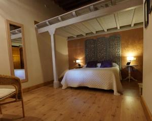 a bedroom with a white bed with blue pillows at Posada de la Triste Condesa in Arenas de San Pedro