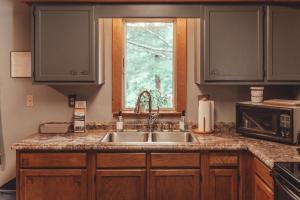 a kitchen with a sink and a window at Patriot Cottage at American Heartland Cabins in Rockbridge