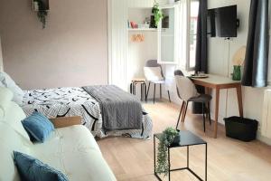 uma sala de estar com uma cama e uma mesa com cadeiras em studio cosy 1er centre Laval vu château et jardin em Laval