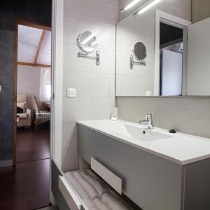 Baño blanco con lavabo y espejo en La Marina Resort, en La Marina